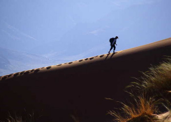 Wanderer am Dünenkamm in der Namib Wüste 