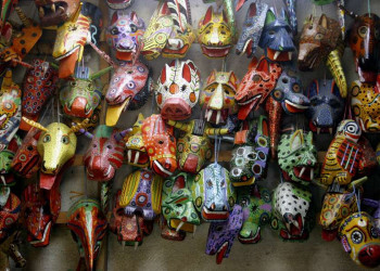 Bunte Holzmasken auf einem Markt in Guatemala