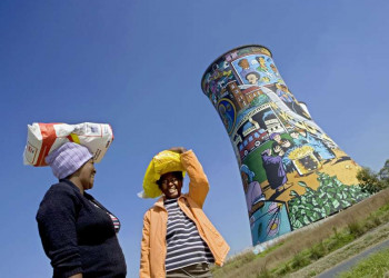 Frauen vor bemaltem Kühlturm in Soweto