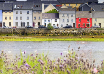 Bunte, geduckt wirkende Häuser am Hafen von Galway