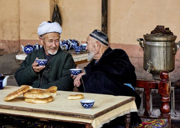 Zwei alte einheimische Männer bei Tee und Brot in Usbekistan