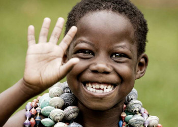 Fröhlich lachender kleiner Junge mit Ketten in Uganda