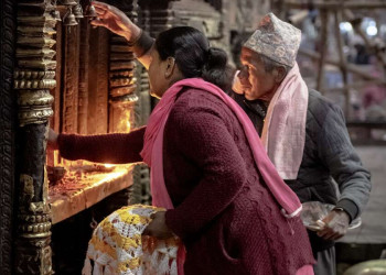 Gläubige entzünden Butterlampen in einem nepalesischen Tempel.
