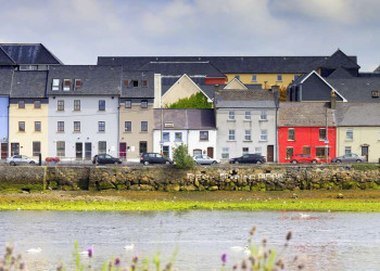 Bunte, geduckt wirkende Häuser am Hafen von Galway