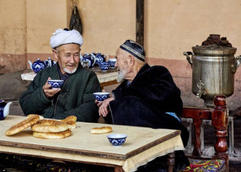 Zwei alte einheimische Männer bei Tee und Brot in Usbekistan