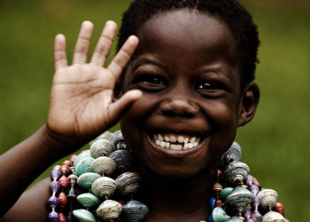 Fröhlich lachender kleiner Junge mit Ketten in Uganda