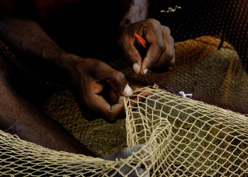 Ein kapverdischer Fischer flickt sein Netz