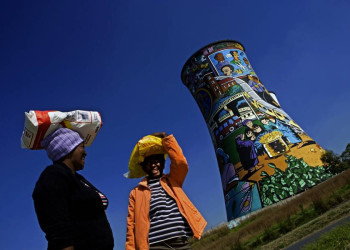Frauen vor bemaltem Kühlturm in Soweto