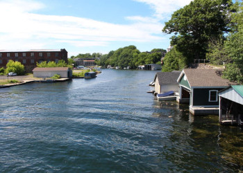 Flusslandschaft mit Bootshäusern