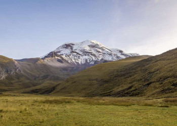 Schneebedeckter Berg und grünes Tal