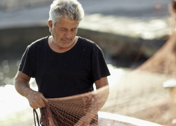 Sonnengegerbter Fischer mit Netz