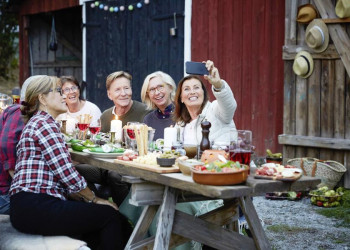 Fröhliche Reisegruppe beim Abendessen in Finnland